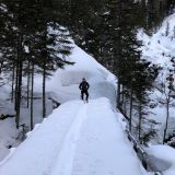 Crossing the snowy bridge at the level of the railing